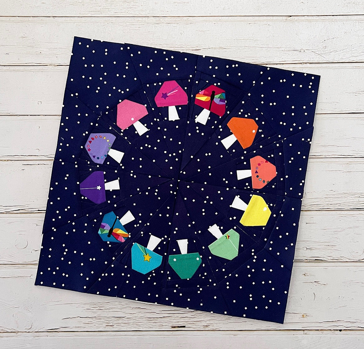 fairy ring paper pieced pattern featuring a ring of mushrooms sewn in fabric