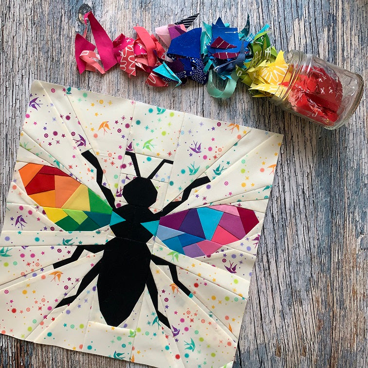 geometric bee paper pieced pattern with rainbow wings sewn in bright fabrics