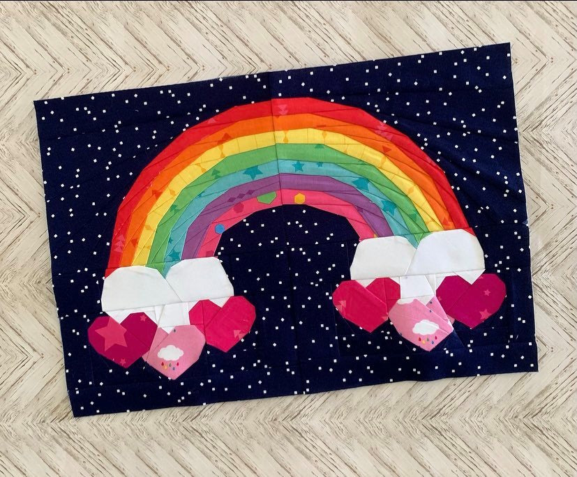 Heart full of rainbow paperp ieced pattern featuring a rainbow with hearts as clouds at the ends of the rainbow sewn in fabric