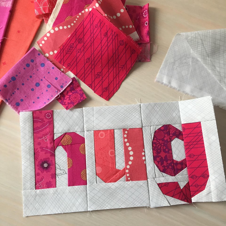 the word hug paper pieced in pink fabrics 