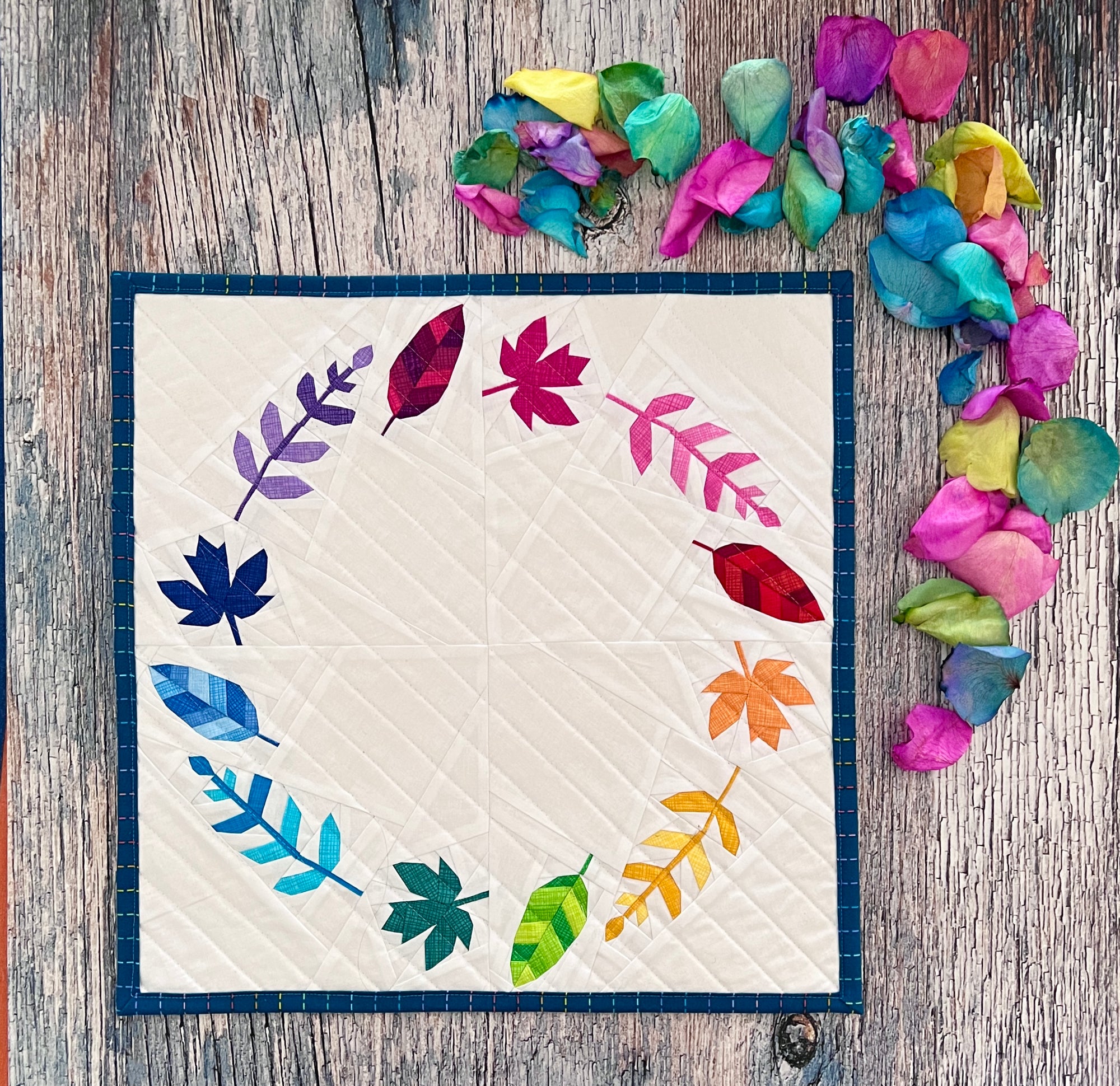 wreath of leaves paper pieced pattern sewn in rainbow fabrics for a mini quilt