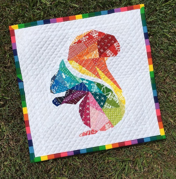 rainbow geometric squirrel paper pieced pattern sewn with rainbow fabrics into a mini quilt