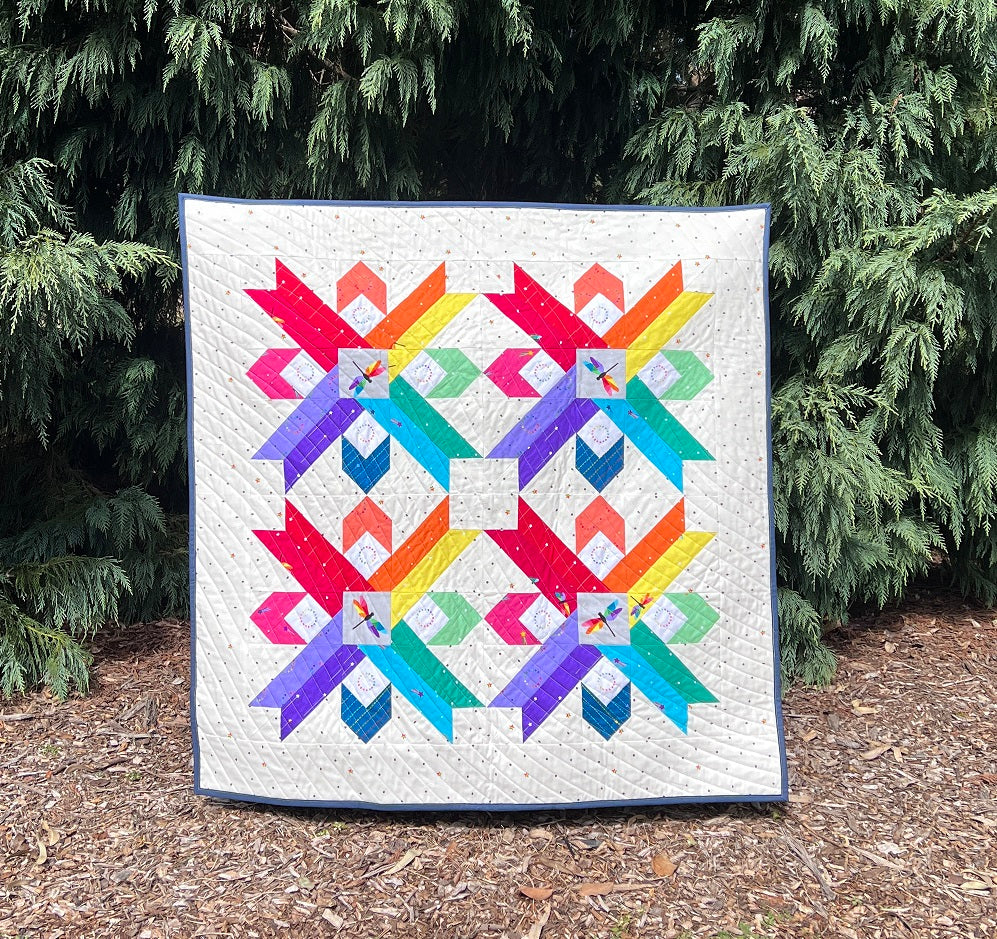 Star Blaze paper pieced pattern sewn in rainbow fabrics into a baby quilt