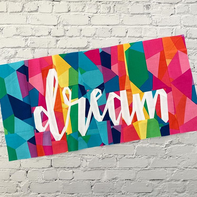 dream in text paper pieced pattern sewn in bright rainbow fabric