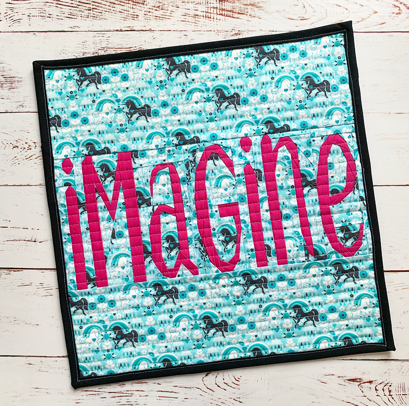 imagine paper pieced text sewn into a mini quilt