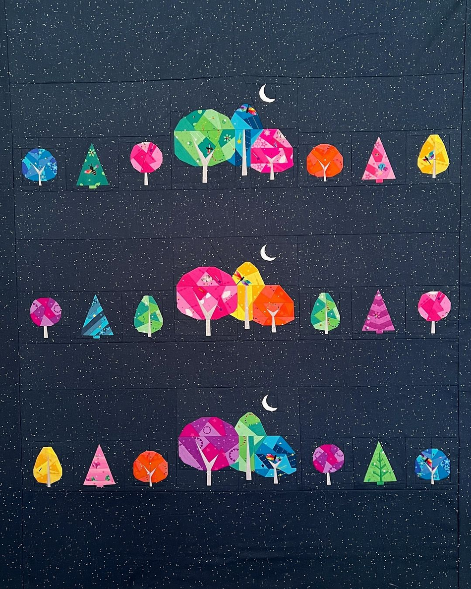 Moonlit stroll foundation paper pieced pattern featuring colourful geometric trees on a dark background sewn in fabric